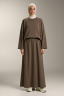 Brown knit sweater and maxi skirt on a hijabi model in a neutral studio